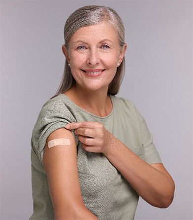 Woman with sleeve rolled up showing bandaid from vaccination