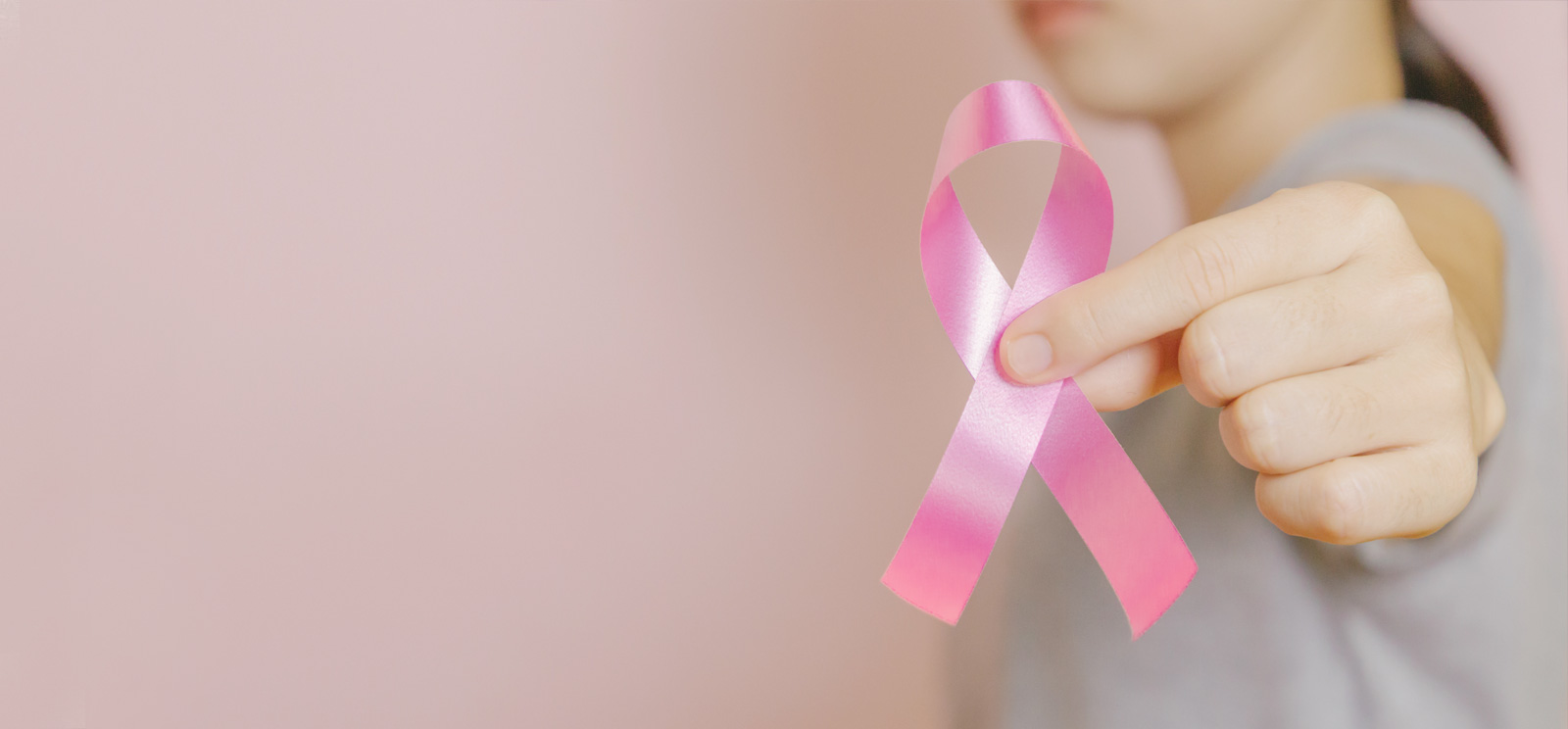 Breast Health month hand holding pink ribbon