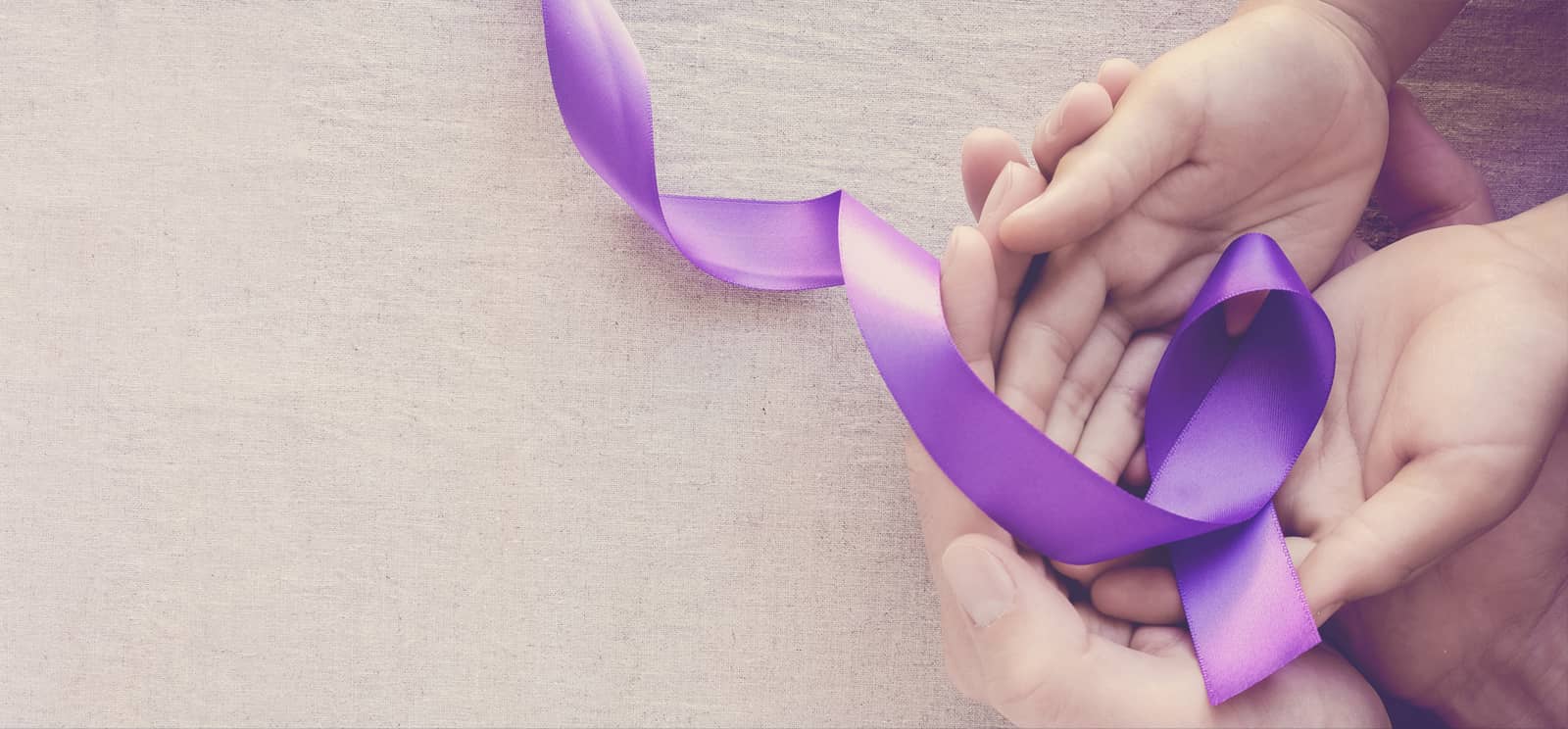 Suicide Prevention month hand holding purple ribbon