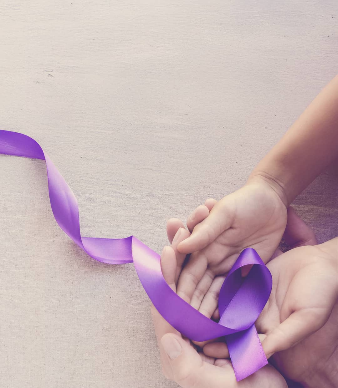 Suicide Prevention month hand holding purple ribbon