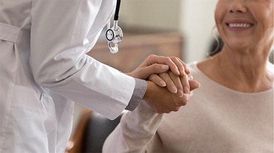 Physician holding womans hand